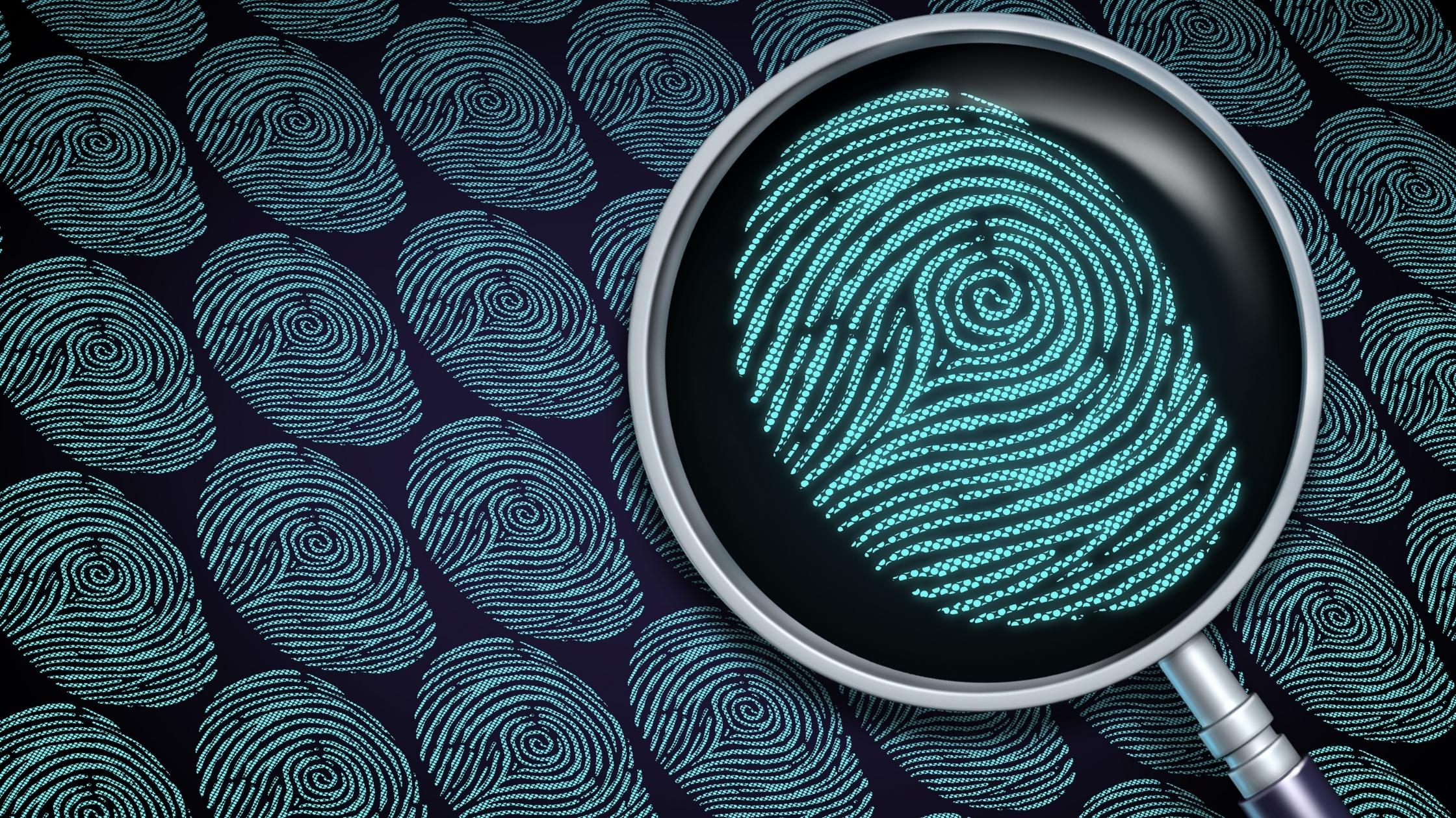 Many fingerprints and a magnifying glass busy identifying one.